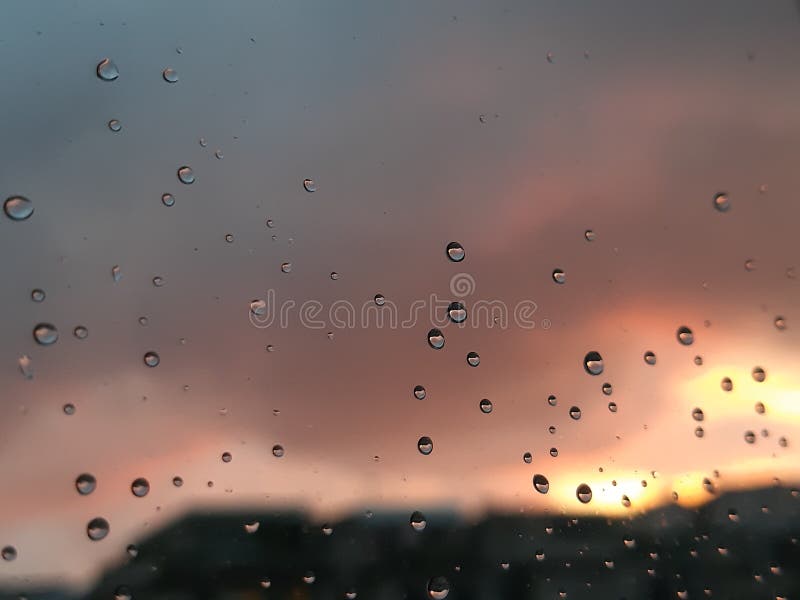 Genova, Italy - 01/17/2019: An incredible sunset over the city of genova after a huge rain and an amazing waterdrop effect over the windows with beautiful orange reflection. Genova, Italy - 01/17/2019: An incredible sunset over the city of genova after a huge rain and an amazing waterdrop effect over the windows with beautiful orange reflection