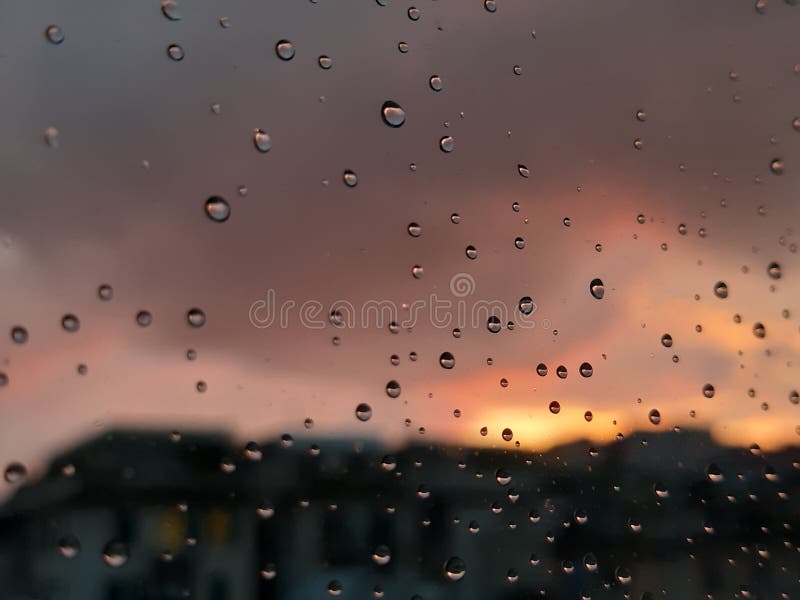 Genova, Italy - 01/17/2019: An incredible sunset over the city of genova after a huge rain and an amazing waterdrop effect over the windows with beautiful orange reflection. Genova, Italy - 01/17/2019: An incredible sunset over the city of genova after a huge rain and an amazing waterdrop effect over the windows with beautiful orange reflection
