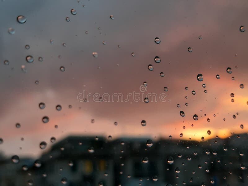 Genova, Italy - 01/17/2019: An incredible sunset over the city of genova after a huge rain and an amazing waterdrop effect over the windows with beautiful orange reflection. Genova, Italy - 01/17/2019: An incredible sunset over the city of genova after a huge rain and an amazing waterdrop effect over the windows with beautiful orange reflection