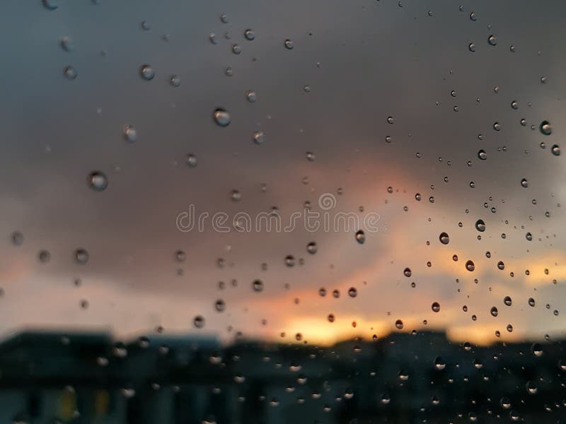 Genova, Italy - 01/17/2019: An incredible sunset over the city of genova after a huge rain and an amazing waterdrop effect over the windows with beautiful orange reflection. Genova, Italy - 01/17/2019: An incredible sunset over the city of genova after a huge rain and an amazing waterdrop effect over the windows with beautiful orange reflection