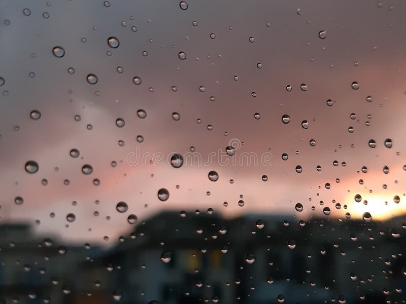 Genova, Italy - 01/17/2019: An incredible sunset over the city of genova after a huge rain and an amazing waterdrop effect over the windows with beautiful orange reflection. Genova, Italy - 01/17/2019: An incredible sunset over the city of genova after a huge rain and an amazing waterdrop effect over the windows with beautiful orange reflection