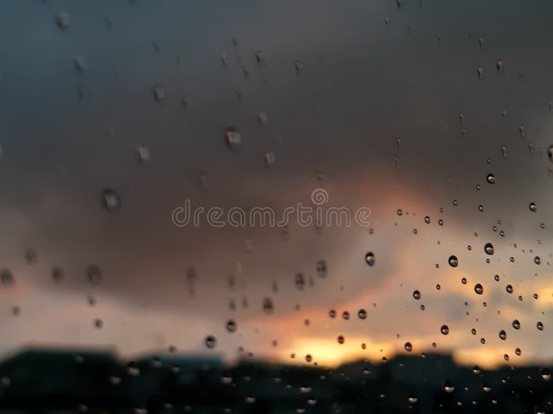 Genova, Italy - 01/17/2019: An incredible sunset over the city of genova after a huge rain and an amazing waterdrop effect over the windows with beautiful orange reflection. Genova, Italy - 01/17/2019: An incredible sunset over the city of genova after a huge rain and an amazing waterdrop effect over the windows with beautiful orange reflection