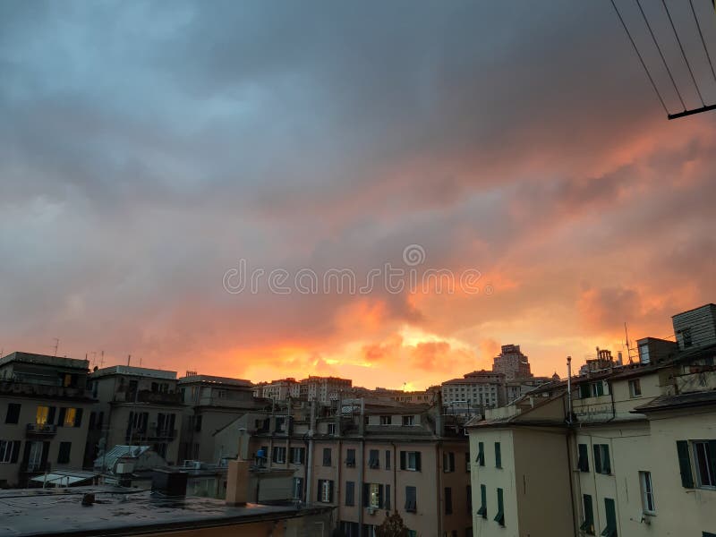 Genova, Italy - 01/17/2019: An incredible sunset over the city of genova after a huge rain and an amazing waterdrop effect over the windows with beautiful orange reflection. Genova, Italy - 01/17/2019: An incredible sunset over the city of genova after a huge rain and an amazing waterdrop effect over the windows with beautiful orange reflection