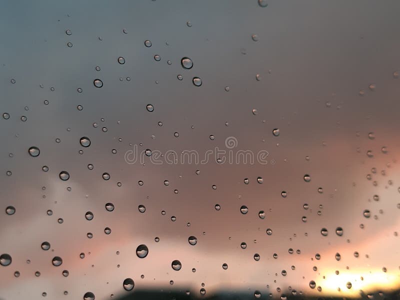 Genova, Italy - 01/17/2019: An incredible sunset over the city of genova after a huge rain and an amazing waterdrop effect over the windows with beautiful orange reflection. Genova, Italy - 01/17/2019: An incredible sunset over the city of genova after a huge rain and an amazing waterdrop effect over the windows with beautiful orange reflection