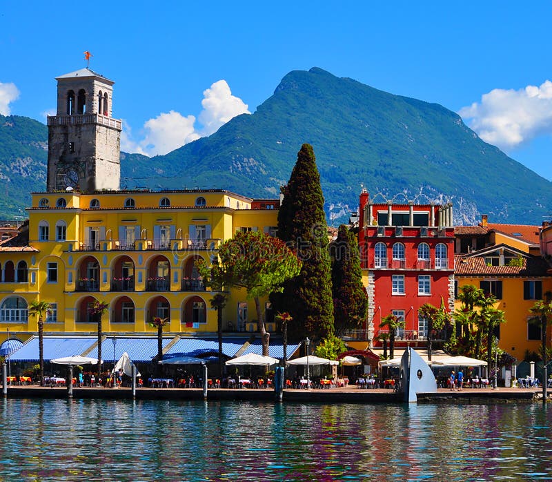 Piękny widok Riva Del Garda bulwar, kawiarnie i restauracje, Jeziorny Garda, region Lombardia, Włochy obraz royalty free Piękny widok Riva Del Garda bulwar, kawiarnie i restauracje, Jeziorny Garda, region Lombardia, Włochy obraz royalty free