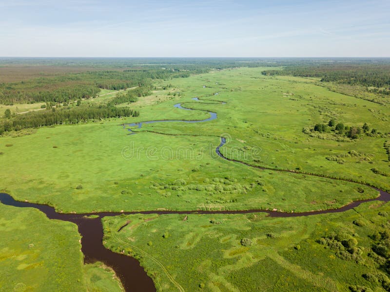 Piękny widok z lotu ptaka meandering rzeka z jaskrawym - zielony pole fotografia stock