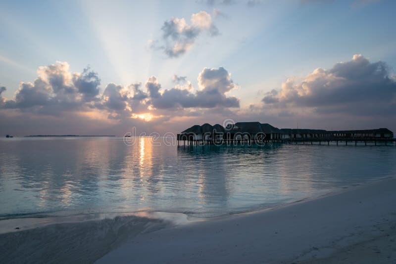 Piękny zmierzch na plaży przegapia wodnych bungalowy w Maldives fotografia royalty free Piękny zmierzch na plaży przegapia wodnych bungalowy w Maldives fotografia royalty free
