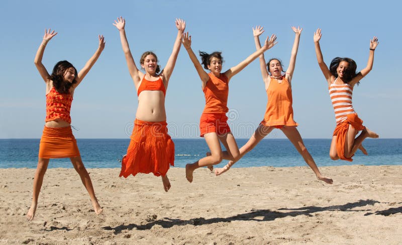 Five girls in orange clothes jumping on the beach. Five girls in orange clothes jumping on the beach