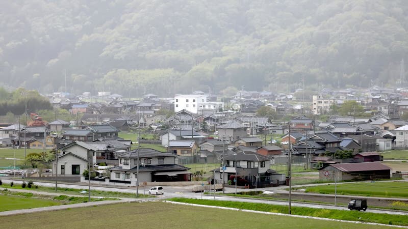 Pkw und Lkw auf der Straße mit japanischer Kleinstadt auf dem Land