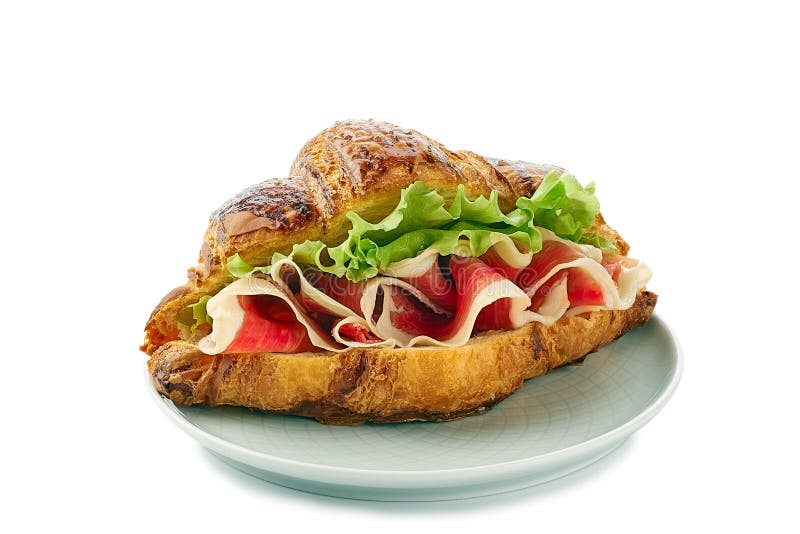 Plaat met croissantsandwich met jamon van ham en sla op wit royalty-vrije stock fotografie Plaat met croissantsandwich met jamon van ham en sla op wit royalty-vrije stock fotografie