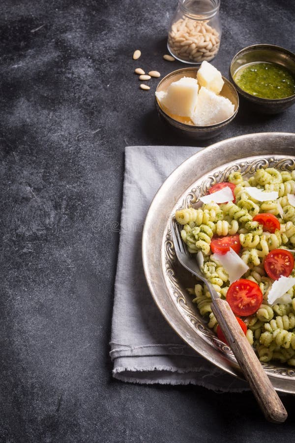 Plaat van deegwarenfusilli met pestosaus op donkere achtergrond royalty-vrije stock afbeelding Plaat van deegwarenfusilli met pestosaus op donkere achtergrond royalty-vrije stock afbeelding