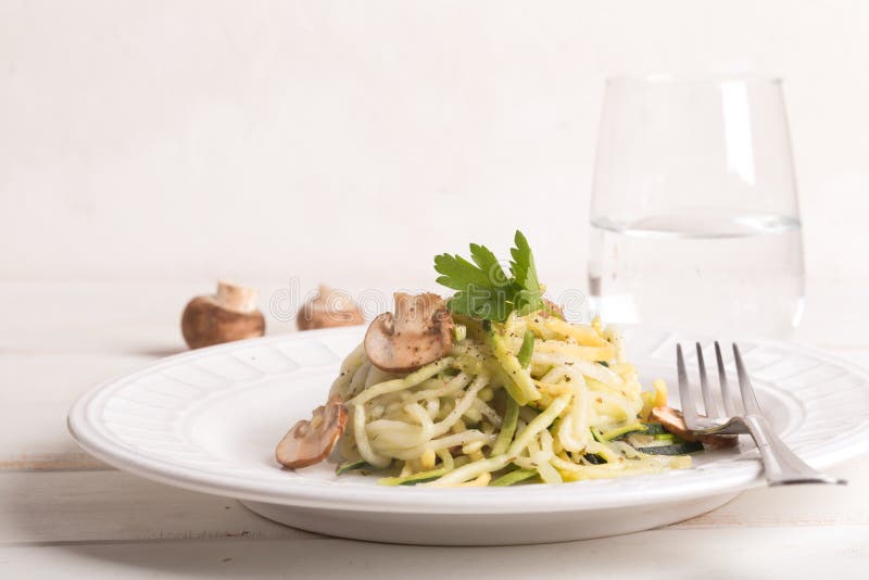 Plaat van spaghetti van courgette en paddestoelsaus op houten lijst wordt voorbereid die royalty-vrije stock foto's Plaat van spaghetti van courgette en paddestoelsaus op houten lijst wordt voorbereid die royalty-vrije stock foto's