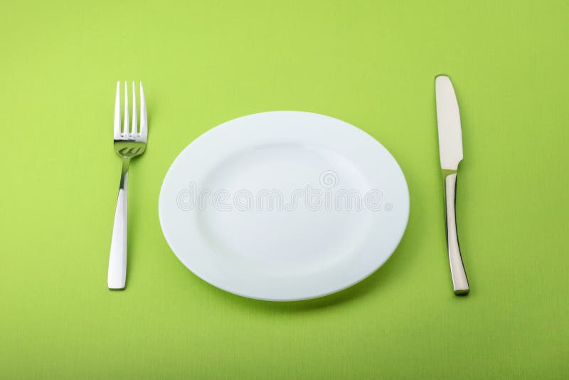 Placa, bifurcación y cuchillo vacíos en fondo verde