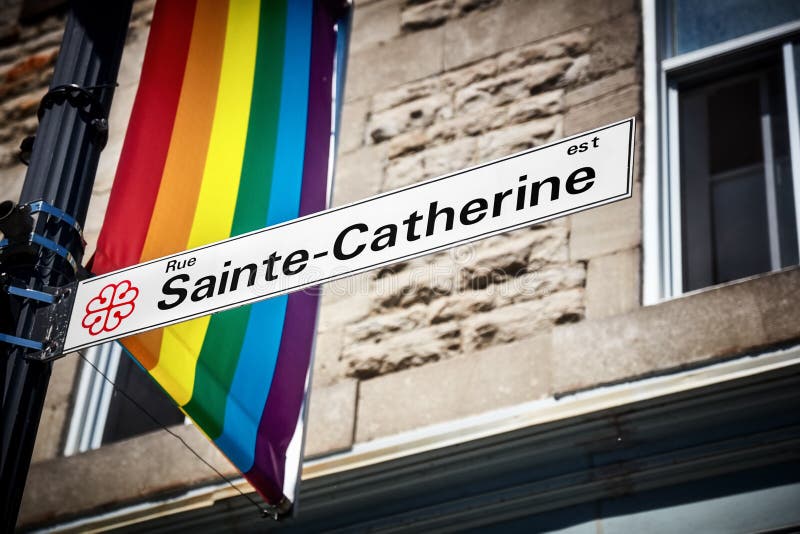 Placa de calle de Sainte Catherine y una bandera del orgullo gay del arco iris