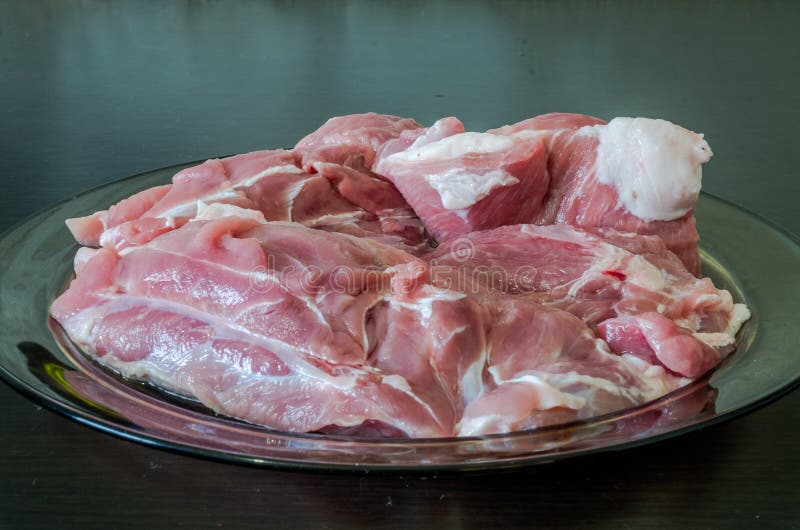 Placa de vidro na tabela preta com carne de carne de porco desbastada fresca para a preparação da refeição imagem de stock Placa de vidro na tabela preta com carne de carne de porco desbastada fresca para a preparação da refeição imagem de stock