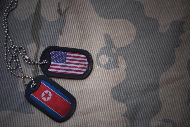 placa do exército, etiqueta de cão com a bandeira de Estados Unidos da América e Coreia do Norte no fundo caqui da textura fotografia de stock royalty free placa do exército, etiqueta de cão com a bandeira de Estados Unidos da América e Coreia do Norte no fundo caqui da textura fotografia de stock royalty free