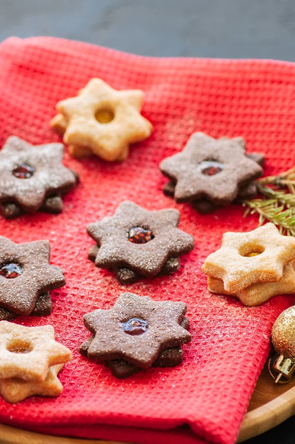 A placa do linzer do chocolate e da baunilha star cookies com raspberr foto de stock A placa do linzer do chocolate e da baunilha star cookies com raspberr foto de stock