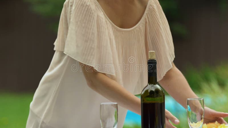 Placas atractivas de la porción de la señora con la ensalada para la cena sana de la familia al aire libre