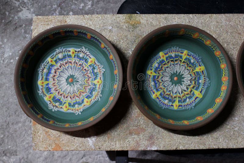 Placas grandes decoram uma placa de argila feita em uma roda de cerâmica usando engobos coloridos Método nacional Flyandrovka búl
