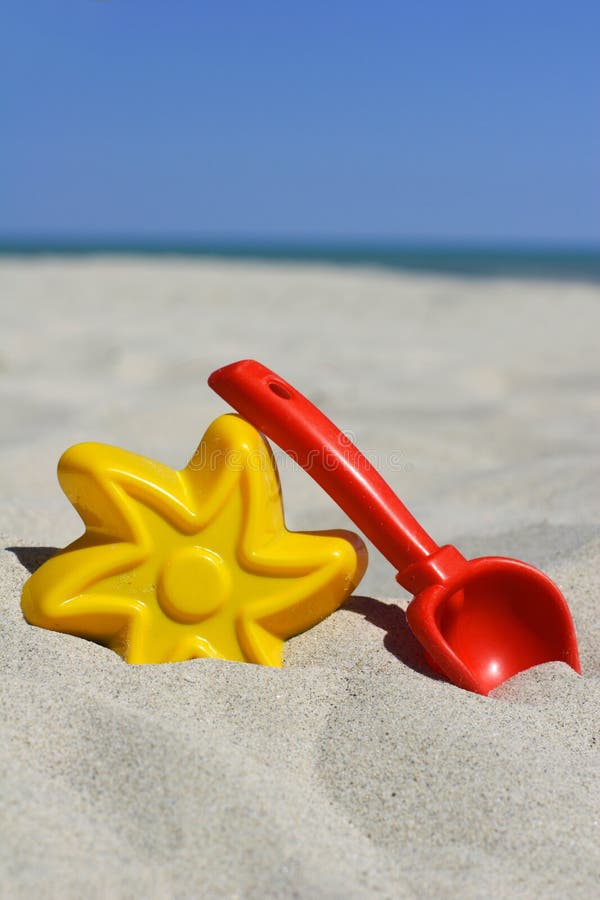 Yellow and red toys on a beach. Yellow and red toys on a beach.