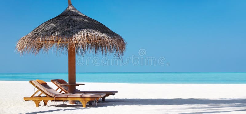 Plage de Beautifu avec les présidences et le parapluie images libres de droits Plage de Beautifu avec les présidences et le parapluie images libres de droits