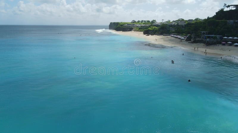 Plage pour des vacances à bali avec surfeurs en bleu océan. vue aérienne clips vidéos