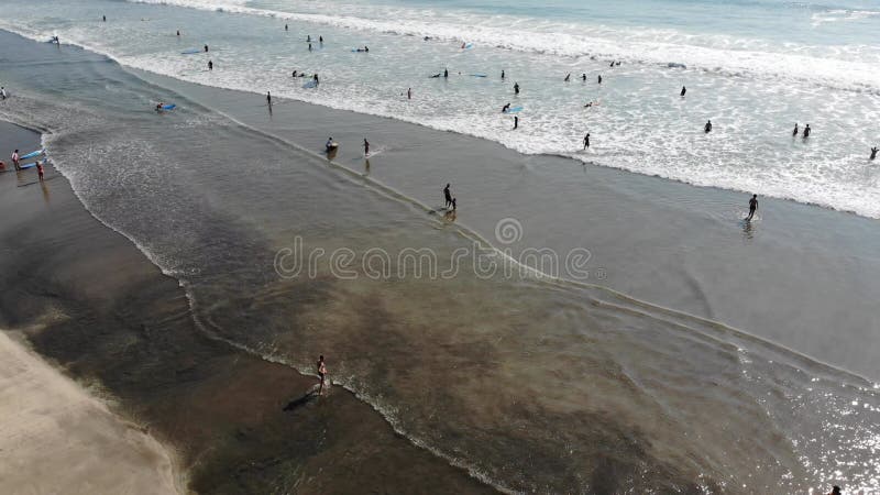 Plage à bali indonesia. ville de badung. eau de mer et touristes en arrière-plan. spot populaire auprès des touristes et des locau banque de vidéos