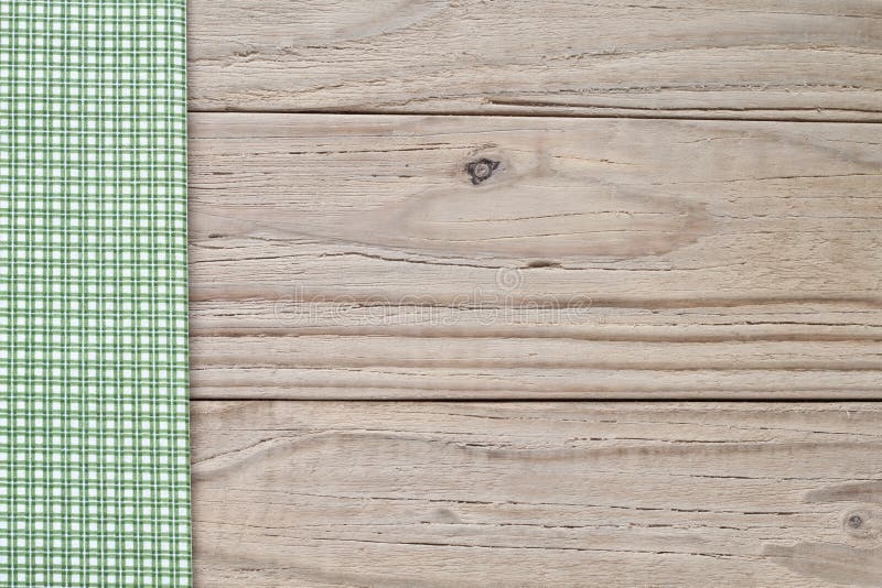 Green and white checkered tablecloth on wooden background. Green and white checkered tablecloth on wooden background
