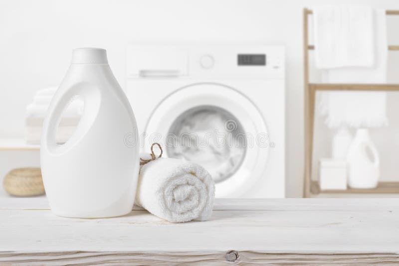 Plain detergent bottle on wood over defocused laundry room interior