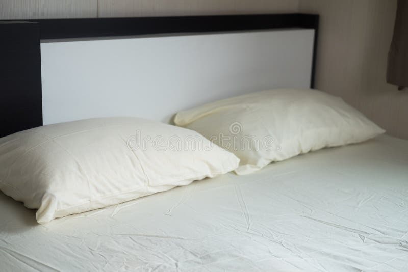 Plain Light Yellow Bed and Pillow in the Bedroom at Home Stock Photo