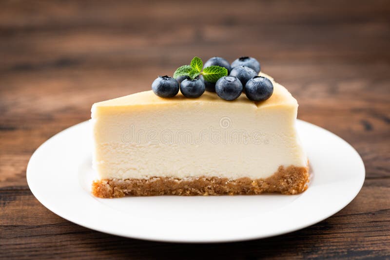 Plain New York Cheesecake Slice Topped With Blueberries And Mint Leaf