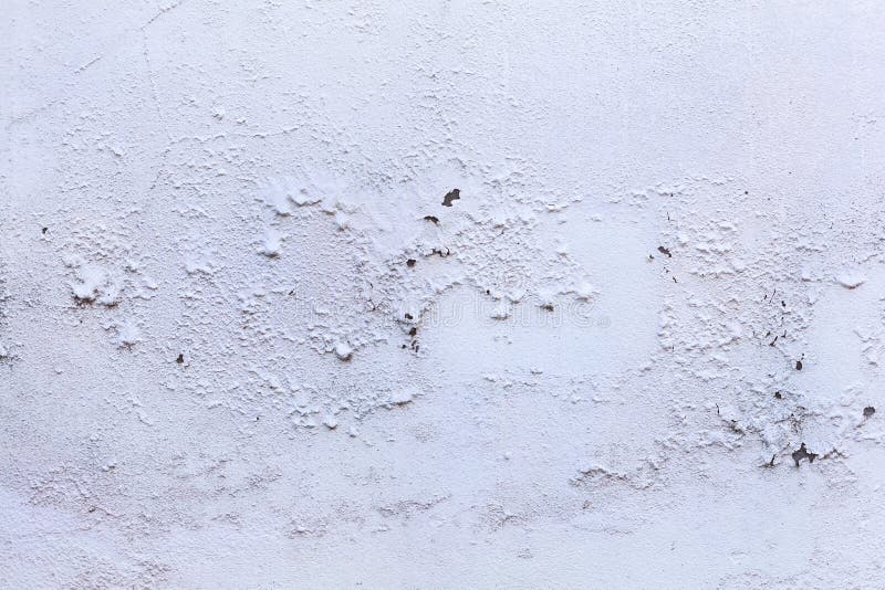 Plain old aged white colored painted faded weathered peeled textured pattern on plastered concrete house wall surface background.