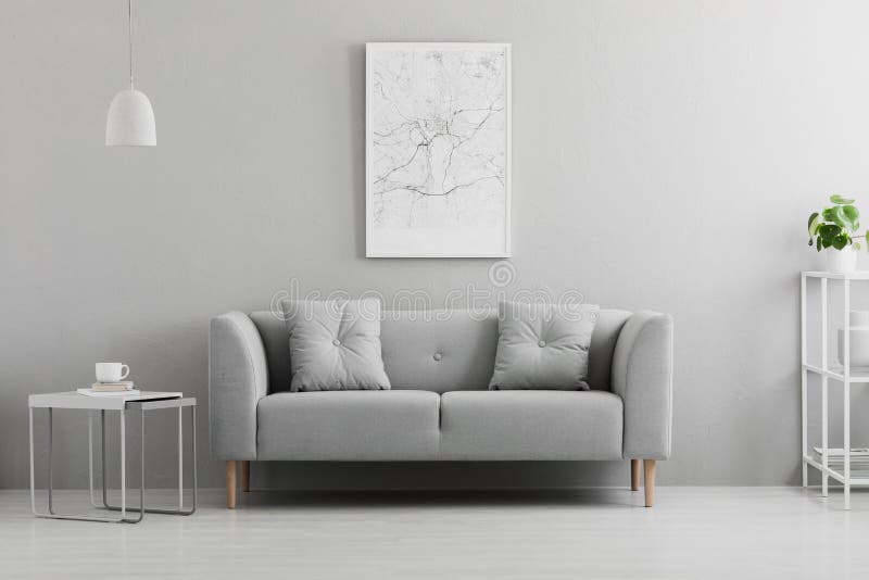 Plakat über grauer Couch im minimalen Wohnzimmerinnenraum mit oben genannter Tabelle der Lampe Reales Foto stockbild Plakat über grauer Couch im minimalen Wohnzimmerinnenraum mit oben genannter Tabelle der Lampe Reales Foto stockbild