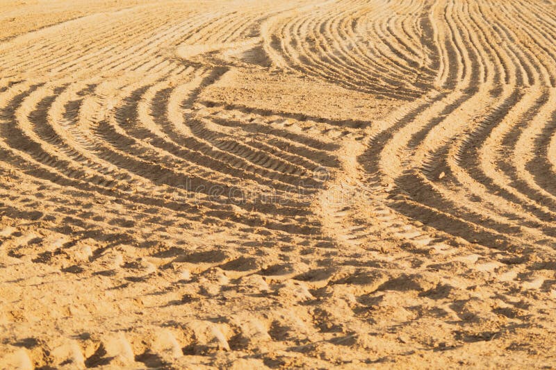 Plan des arêtes et des sillons courbés sur un terrain sablonneux. Traces sur le sable photographie stock Plan des arêtes et des sillons courbés sur un terrain sablonneux. Traces sur le sable photographie stock
