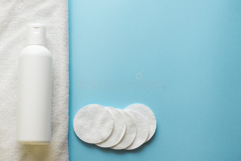 Plan lekmanna- sammans?ttning med block f?r lotion och f?r bomull f?r hudomsorg p? bl? bakgrund, kopieringsutrymme royaltyfri fotografi Plan lekmanna- sammans?ttning med block f?r lotion och f?r bomull f?r hudomsorg p? bl? bakgrund, kopieringsutrymme royaltyfri fotografi