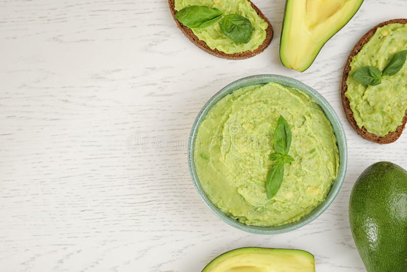 Plan lekmanna- sammansättning med guacamole, smörgåsar och avokadon på trätabellen Utrymme f?r text royaltyfri fotografi Plan lekmanna- sammansättning med guacamole, smörgåsar och avokadon på trätabellen Utrymme f?r text royaltyfri fotografi