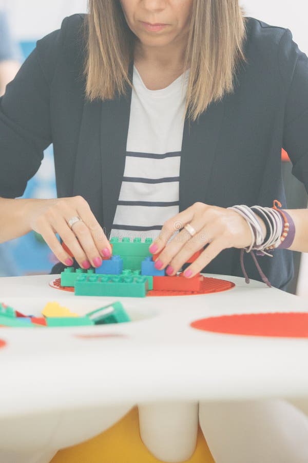 Brune Adulte Jouant Le Lego Dans L'école Maternelle à La Table