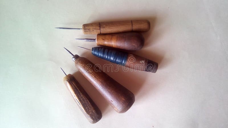 Plan rapproché d'un ensemble de cinq alênes Vieux outils avec les poignées en bois sur un fond clair photographie stock libre de droits Plan rapproché d'un ensemble de cinq alênes Vieux outils avec les poignées en bois sur un fond clair photographie stock libre de droits