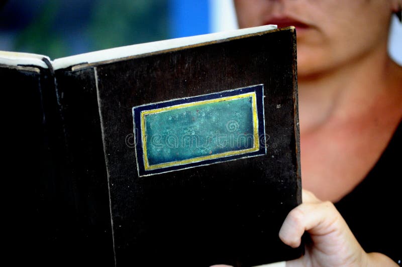 Plan rapproché d'un livre ou d'un manu d'isolement sans le titre avec une personne lisant derrière sur le fond - l'espace pour l' images libres de droits Plan rapproché d'un livre ou d'un manu d'isolement sans le titre avec une personne lisant derrière sur le fond - l'espace pour l' images libres de droits