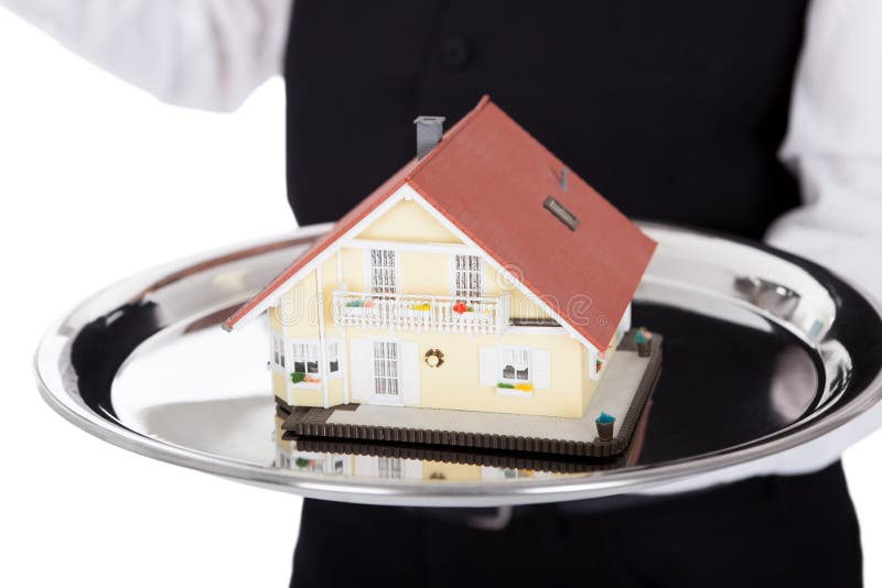 Plan rapproché d'un maître d'hôtel avec le modèle d'une maison image stock Plan rapproché d'un maître d'hôtel avec le modèle d'une maison image stock