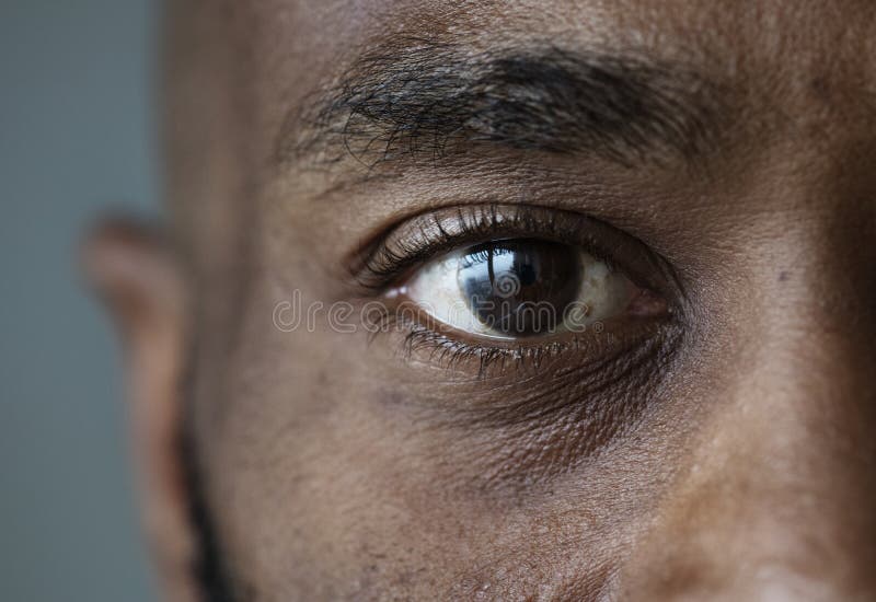 Plan rapproché d'un oeil d'une expression du visage d'homme de couleur image libre de droits