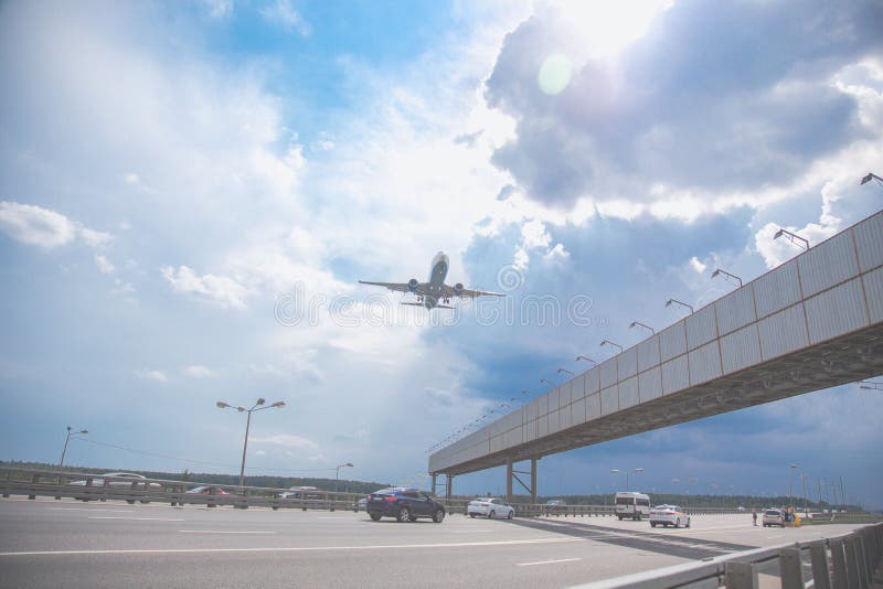 Plan rapproché d'un vol d'avion de passagers au-dessus d'une route contre un ciel bleu photos libres de droits Plan rapproché d'un vol d'avion de passagers au-dessus d'une route contre un ciel bleu photos libres de droits