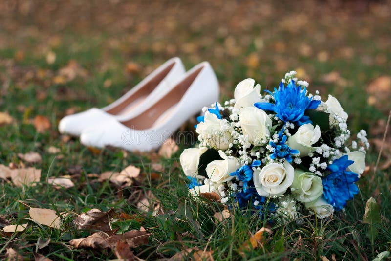 Plan rapproché de bouquet nuptiale de rose de jaune sur le fond de ses chaussures de blanc sur l'herbe verte photo stock Plan rapproché de bouquet nuptiale de rose de jaune sur le fond de ses chaussures de blanc sur l'herbe verte photo stock