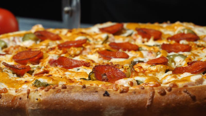 Plan rapproché de chef dans les gants blancs utilisant un coupeur de pizza coupant en tranches la pizza délicieuse avec le salami images libres de droits Plan rapproché de chef dans les gants blancs utilisant un coupeur de pizza coupant en tranches la pizza délicieuse avec le salami images libres de droits