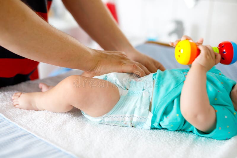 Plan rapproché de couche-culotte changeante de père de sa fille nouveau-née de bébé image libre de droits Plan rapproché de couche-culotte changeante de père de sa fille nouveau-née de bébé image libre de droits