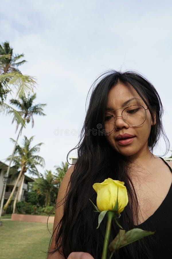Plan rapproché de fille avec des verres, tenant la fleur rose jaune photos libres de droits Plan rapproché de fille avec des verres, tenant la fleur rose jaune photos libres de droits