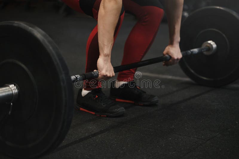Plan rapproché de l'athlète féminin de crossfit se préparant aux poids de levage au gymnase image libre de droits Plan rapproché de l'athlète féminin de crossfit se préparant aux poids de levage au gymnase image libre de droits