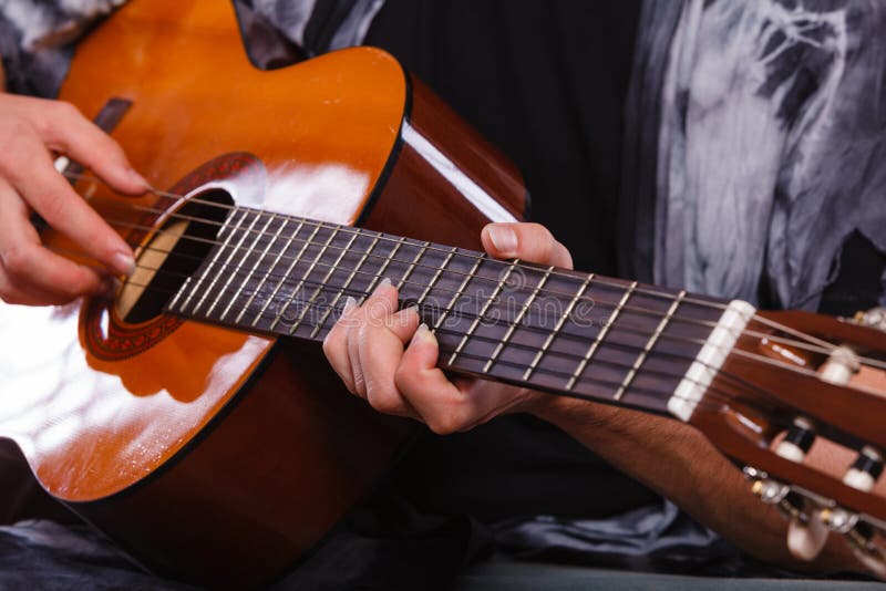 Plan rapproché de l'homme jouant la guitare acoustique photographie stock libre de droits Plan rapproché de l'homme jouant la guitare acoustique photographie stock libre de droits