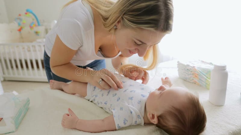 Plan rapproché de la jeune mère gaie parlant à son bébé garçon et jouant avec lui clips vidéos