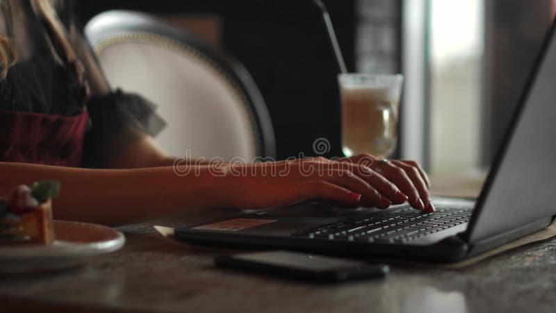 Plan rapproché de la main de femme d'affaires dactylographiant sur le clavier d'ordinateur portable Le plan rapproché d'une femel
